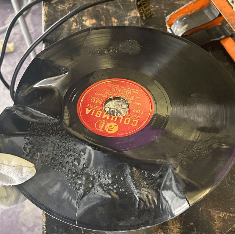 A large Columbia vinyl record showing bubbling and surface evaporation from heating